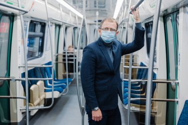 2020 'de Coronavirus krizi. Adam yer altında işe gidip geliyor, toplu taşıma araçlarını kullanıyor, virüse karşı koruyucu yüz maskesi kullanıyor, karantina döneminde koruyucu maske takıyor.