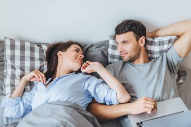 Büyük bir sevgi ile güzel bir kadın bakar kocası, sadece uyanık, dizüstü bilgisayar, birbirimizi mutlu Günaydın ve klavye erkek diyor. Eğlence ve ilişki kavramı