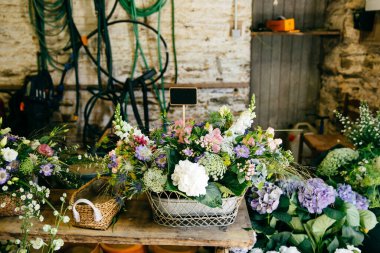 Çiçek ahşap backets içinde çeşididir. Ahşap masa üzerinde duran Bouquetes. Hoş kokulu çiçeklerle ile kompozisyon. Dekorasyon konsepti. Çiçekçi dükkanı güzel çiçekler ile