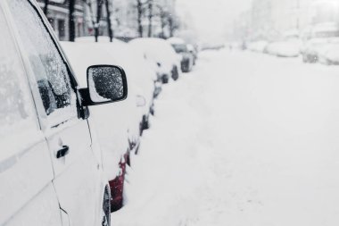 Kış yolunda ya da otoparkta bir sürü araba var. Karlı şehir. Kış boyunca kar yağışı. Trafik ve kötü hava koşulları. Şehir manzarası. Arabalar karda sıkıştı