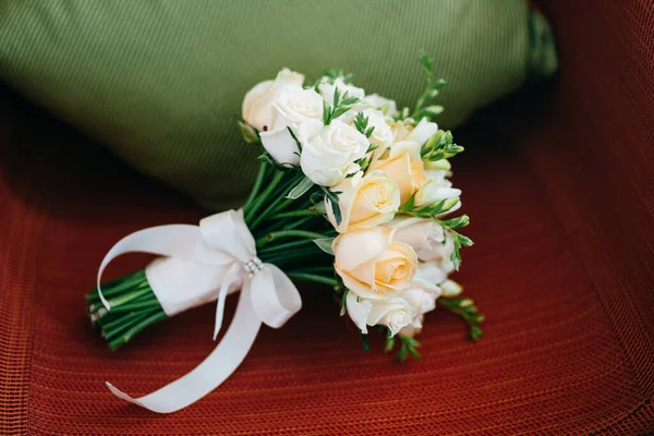 White flowers with ribbons on armchair. Wedding symbol. Festive event. White roses. Beautiful roses. Festive event