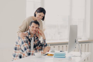 Değer veren kadın, kocasına iş görüşmesi yapan, iş meselelerini çözmeye çalışan, not defterine bilgi yazan ve bilgisayarda çalışan girişimcisine yardım eder. Aile çiftleri mali işlerle ilgilenir
