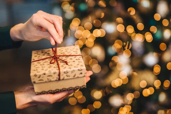 Mujer Irreconocible Envuelve Caja Regalo Sobre Árbol Navidad Con Luces —  Fotos de Stock