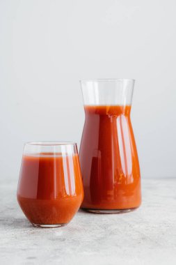 Beyaz arka plan üzerinde izole vitaminler içeren domates suyu iki şişe. Dikey atış. Taze sıkılmış smoothie. Sağlıklı içecek