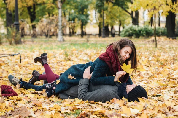 사랑하는 남녀는 즐거운 시간을 보내고 나뭇잎으로 뒤덮인 서로를바라보고 바보같은 놀이를 — 스톡 사진