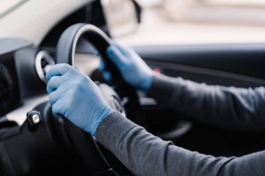 Taşıma konseptinde sağlık hizmeti. Tanınmayan sürücü lastik koruyucu eldiven giyer. Salgın sırasında Coronavirus sürücüsü arabasından korur. Covid-19 koruma konsepti. Hastalık, enfeksiyon, karantina