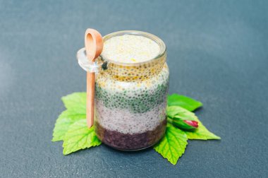 Sağlıklı tatlı ve doğru beslenme konsepti. Tahta kaşıkla cam kavanozda Chia puding. Chia tohumu. Superfood. Seçici odak. Sütlü tatlı