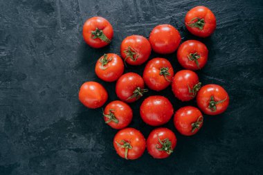 Koyu arka planda olgun ıslak kırmızı domates hasat. Üst te. Kopya alanı. Organik taze sebzeler. Çiğ yemek. Temiz yeme konsepti
