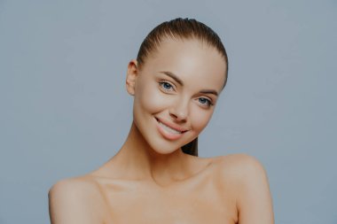 Güzel, kadınsı bir kadın şehvetli ve rahat bakar, güzellik ve tenle ilgilenir, başını eğip çıplak omuzlarını kaldırır, spa ameliyatlarından sonra kendini harika hisseder. Şefkat ve kozmetoloji.