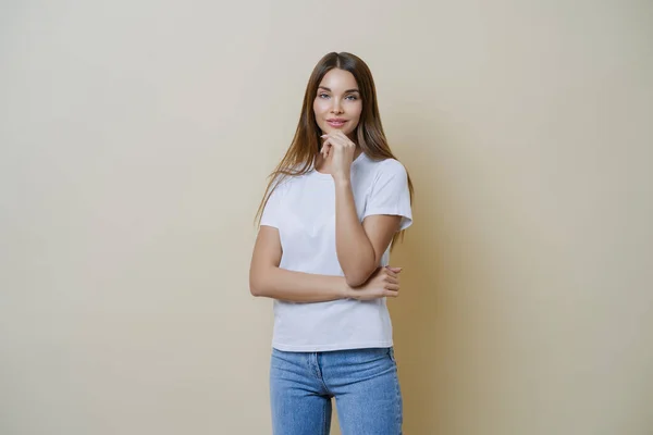 Foto Morena Joven Europea Sostiene Barbilla Lleva Camiseta Blanca Jeans — Foto de Stock