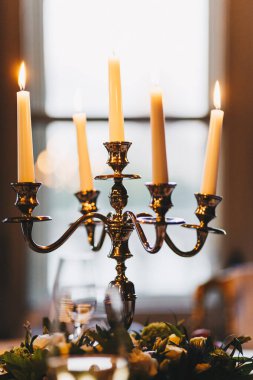 Retro şamdan hizmet masada beş beyaz mum yanan mumlar ile. Antika stili ve dekorasyon konsepti. Lüks restoran sakin atmosfer. Festival dekor.