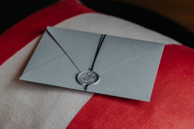 Zarif gri kağıt davetiye kapalı atış kanepe yastık üzerinde yatıyor. Yıldönümü veya düğün için davet. Dekorasyon