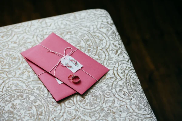 躺在粉红色的邀请卡上的结婚戒指 婚礼的筹备工作和装饰品 由新郎和新娘的婚礼卡 爱情和浪漫的概念 — 图库照片