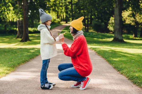 stock image People, relationship, parenthood and childhood concept. Beautiful mother plays with her little daughter in park, gives yellow leaf, have sincere emotions and feeling or love to her lovely daughter