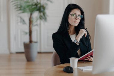 Odaklanmış kadın notlar yazıyor, çevrimiçi kurs okuyor, ortak çalışma alanı üzerinde çalışıyor, fikirleri birleştiriyor. İş verimliliği.