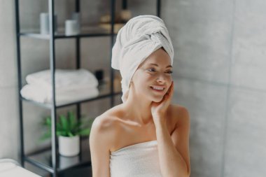 Doğal makyajlı gülümseyen spa kadını duştan sonra tazelenir, tuvalette sağlıklı tene dokunur..