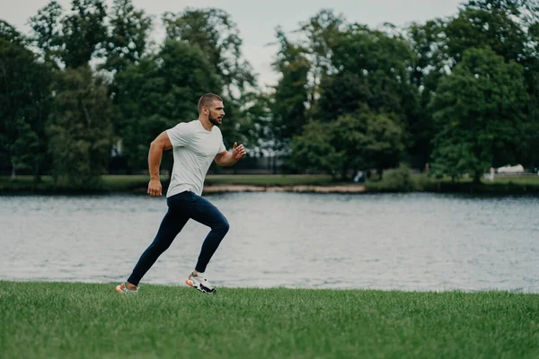 アクティブな髭を生やした男は 自然の中で走り マラソンの準備をし 動きの瞬間を捉えます スポーツとウェルネスのコンセプト — ストック写真