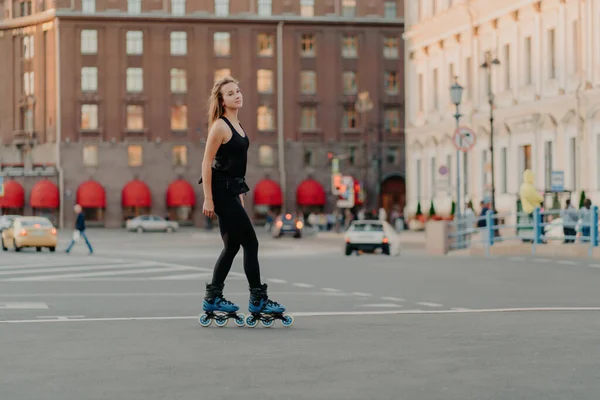 Slim Woman Rollerblades Asphalt Dressed Black Sportswear Enjoys Outdoor Activities — Stock Photo, Image