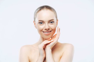 Kusursuz derisi olan çıplak bir kadın, dokunaklı çene çizgisi, şekilli saç, doğal makyaj, çıplak omuzlar, beyaz arka planda. Güzellik konsepti.