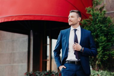 Zeki erkek bankacı iş planları yapar, bina yakınında poz verir, iş hayatı tarzını resmeder..