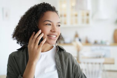 Gülümseyen kız evde hoş bir telefon görüşmesi yapmaktan hoşlanıyor. Çift ırklı gençler iyi haberler alıyor, akıllı telefondan mutlu sohbetler ediyorlar..