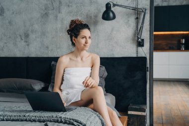 Serbest İşçi Hafta Sonu: Havlulu Avrupalı kadın otelde yataktan yatağa çalışıyor.