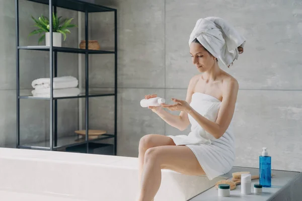 ヨーロッパの美しさをタオルで包み お風呂の後にボディクリームを適用します 女性のシャワー 自宅で朝 抗セルライト マッサージ ボディケア — ストック写真