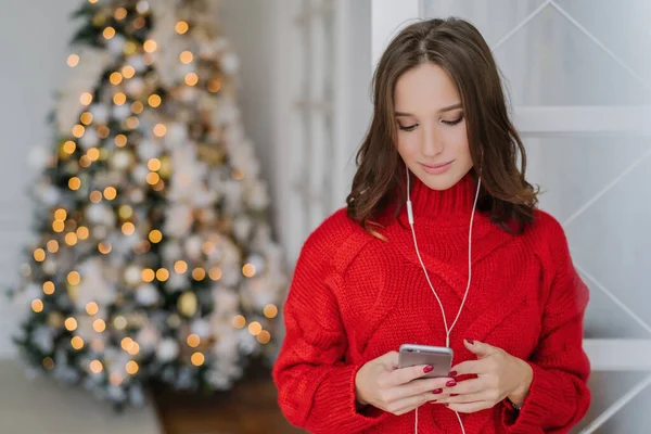 Focused Woman Reads News Phone Earphones Indoor Fir Tree High — 스톡 사진