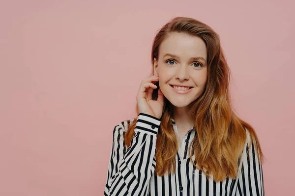 Çizgili Bluzuyla Gülümseyen Genç Bir Kadın Dalgalı Kızıl Saçlı Dokunaklı Stok Fotoğraf