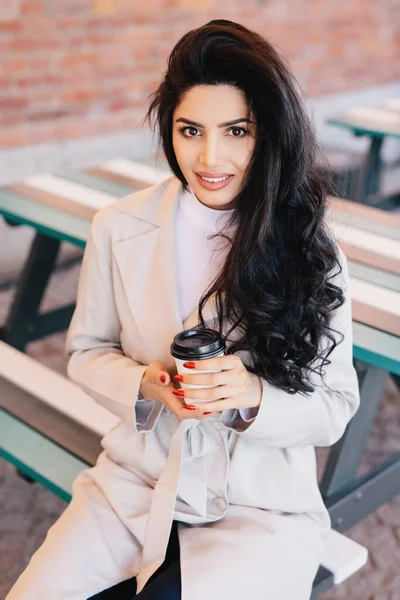 Mujer Adorable Aire Libre Abrigo Blanco Sorbiendo Café Sonriendo Para Imagen De Stock