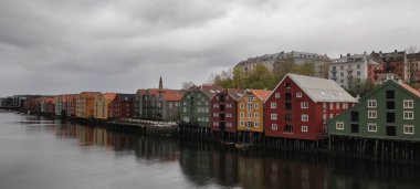 Trondheim, Norveç - 8 Mayıs 2022: Nidelva nehri boyunca tipik renkli ahşap binalar