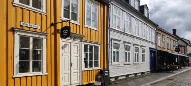 Trondheim, Norveç - 8 Mayıs 2022: Nidelva nehri boyunca yığınlar üzerinde tipik renkli ahşap binalar