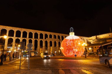 Segovia, İspanya - 4 Ocak 2022: Plaza del Azoguejo arka planda dev bir top ve su kemeri şeklinde noel süsü ile