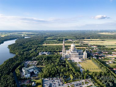 Liche Leydisi Bazilikası 'nın hava manzarası açık mavi gökyüzü altında yemyeşil orman, göl ve kırsal alanla çevrilidir. Polonya 'da vuruldu..