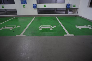 Üç elektrikli araba şarj istasyonu olan bir otopark..
