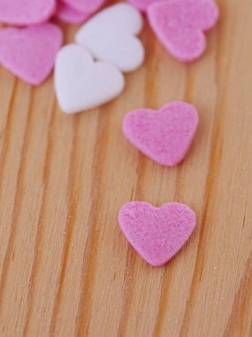 Pembe ve beyaz kalpleri olan ahşap bir masa..