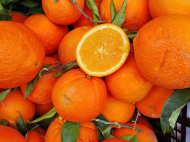 Bir portakal demeti ve ikiye bölünmüş bir portakal. Portakallar taze ve olgun. Zenginlik ve tazelik kavramı.