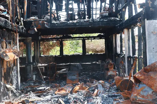 Bir bina yanıyor ve içerisi enkazla dolu. Sahne yıkım ve kaostan ibarettir.