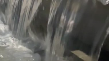 İçinden bir sürü su akan bir şelale. Su çok berrak ve bir nehirden geliyor gibi görünüyor.