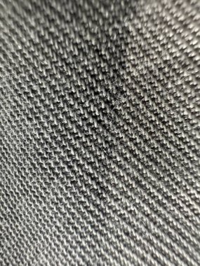 Bir sürü deseni olan siyah ve beyaz bir kumaşa yaklaş. Kumaş çok yumuşak olmayan bir malzemeden yapılmış, ama çok fazla detay içeriyor.