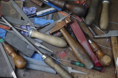 Çekiç, pense ve makas da dahil olmak üzere araç gereç koleksiyonu bir masanın üzerine saçılmıştır. Yaratıcılık ve işçilik kavramı, çünkü bu araçlar çeşitli DIY projeleri ve onarımları için gereklidir