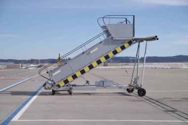 Yerde büyük metal merdiven var. Merdiven sarı ve siyah.