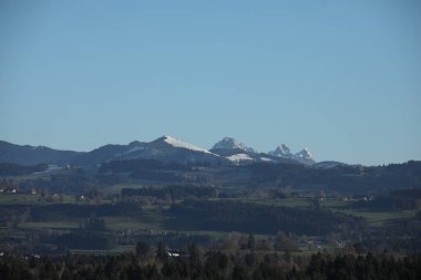 Dağlar karla kaplı ve gökyüzü açık ve mavi. Huzurlu ve huzurlu bir sahne.