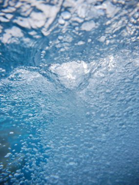 Görüntü, bol köpüklü bir su kütlesi. Kabarcıklar suyun her tarafına dağılmış, hareket ve enerji hissi yaratıyor. Sahne heyecan ve oyundan ibarettir..