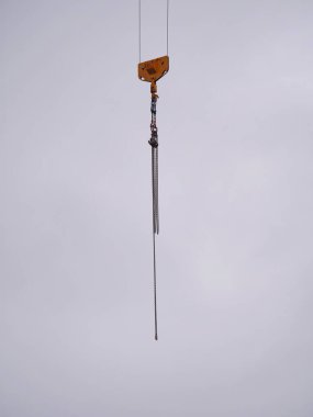 Vinçten sallanan bir zincir. Zincir uzun ve ince..