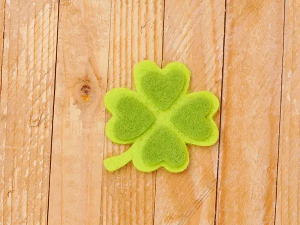 Üzerinde dört kalp olan yeşil bir yonca tahta bir yüzeye oturur. Yonca şans ve iyi talihin sembolüdür, ve kalpler sevgiyi ve sevgiyi temsil eder. Olumluluk ve umut kavramı.