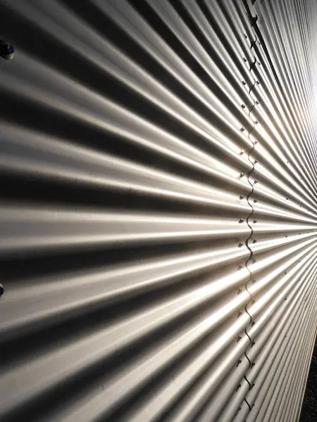 Görüntü, bir dizi çıkıntısı olan metal bir duvarın yakın çekimi. Sırtlar farklı boyutlarda ve bir derinlik ve doku hissi yaratacak şekilde boşluktalar..