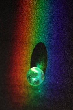 Top gökkuşağında bir delikte duruyor. Top yeşil ve çukur siyah.