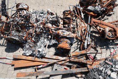 Paslanmış metal ve yanmış enkaz yığını. Sahne yıkım ve kaostan ibarettir.