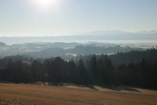 Arka planda geniş bir dağ sırası olan güzel bir manzara. Gökyüzü açık ve güneş parlıyor.